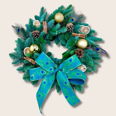 This striking fresh spruce wreath is adorned with scented cinnamon, dried lime slices, pine cones, gold baubles and those bold peacock feathers and matching bow. 