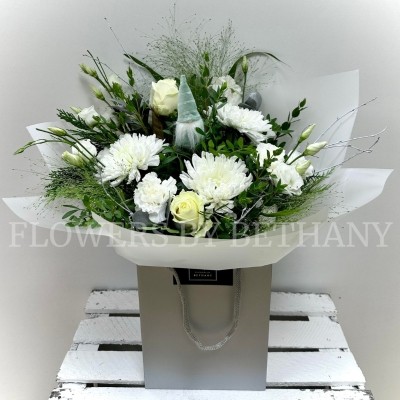 Mixed white bouquet bursting with roses, blooms, carnations and lizianthus to name a few. Hand tied in water and presented in cellophane wrap and our signature gift bag. 