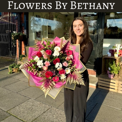 Romantic AF bouquet featuring red roses, pink germini, white chrysanthemums, and carnations with gold-leaf accents, wrapped in pink and gold cellophane hand tied in water. 