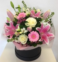 Luxury hat box bouquet including mixed pink tones. Scented flowers such as roses, lily, wax flower and freesia. 