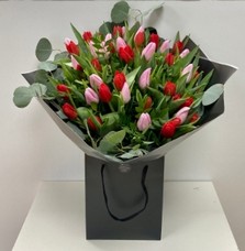 Stunning bomb of pink and red English grown tulips. Finished with eucalyptus collar. 