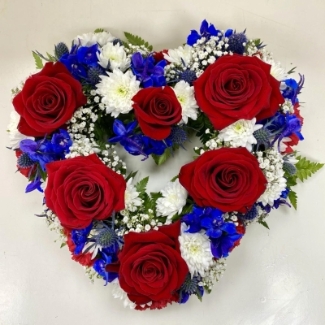 A mixed floral open heart funeral tribute in the British colours of red, white and blue. 