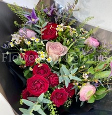 Natural hand tied bouquet filled with rich red and pink tones. Design including roses, clematis and a mix of other seasonal favourites. 