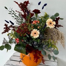 Medium orange pumpkin with floral arrangement including oak leaf, eucalyptus, germini, berries & other seasonal verities. 